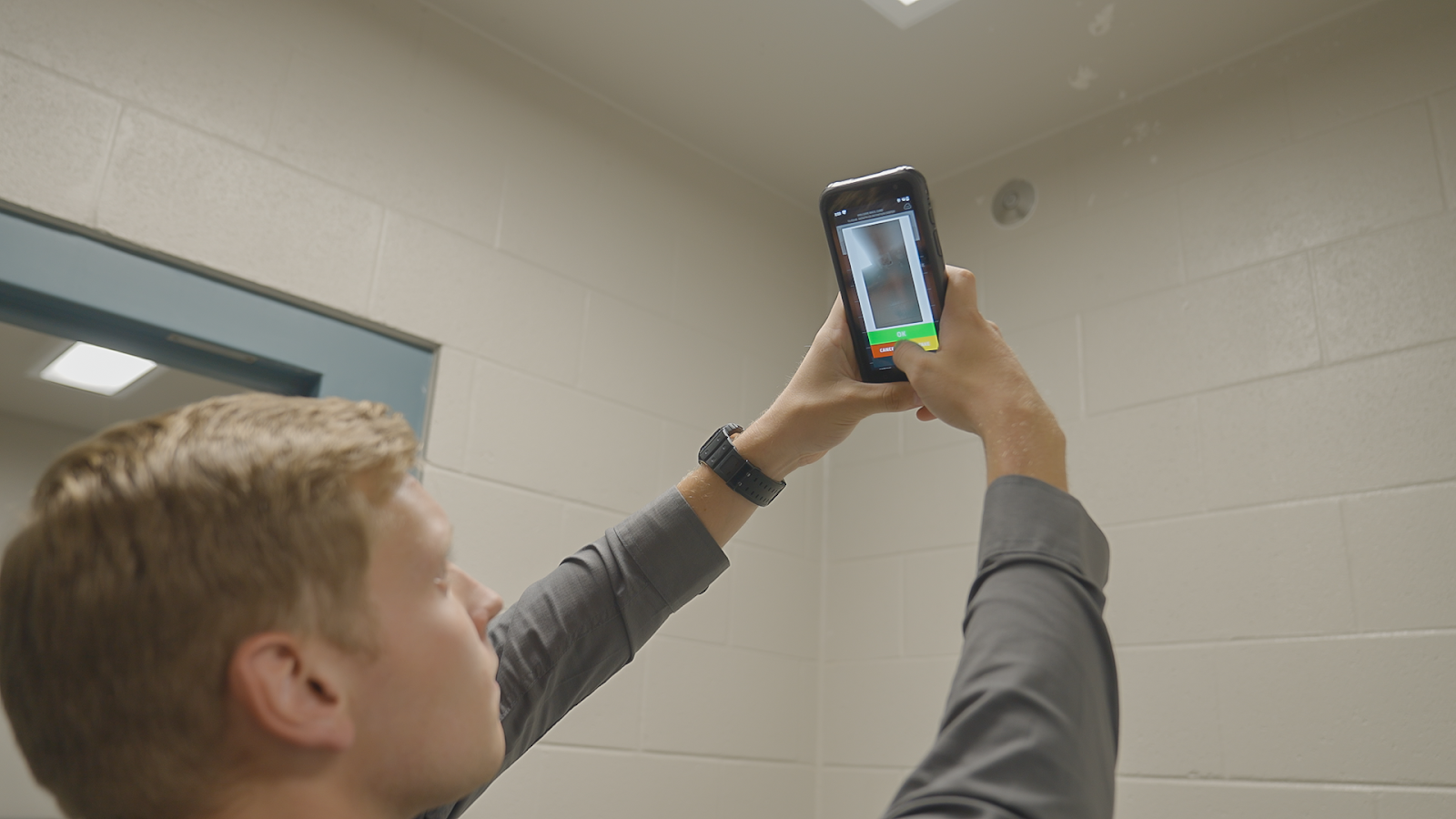 Corrections officer using SPARTAN to take picture of evidence