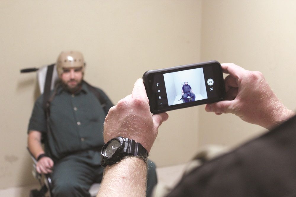 spartan taking image of inmate in restraint device