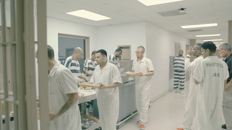 inmates in line receiving meals