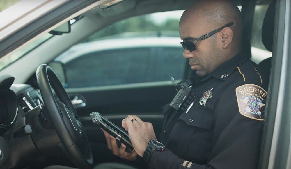 officer in car on tablet