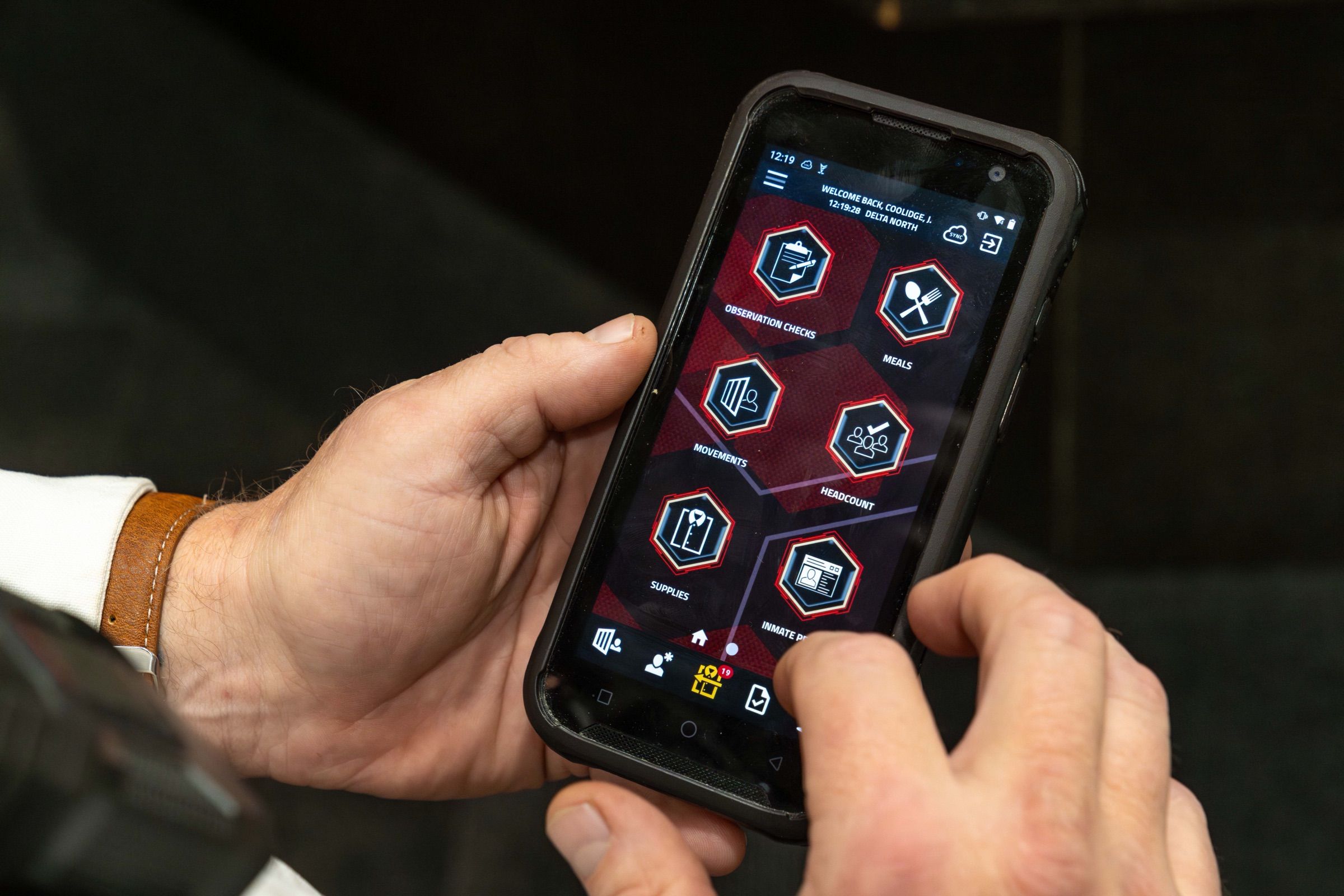 Correctional officer holding a rugged handheld scanner