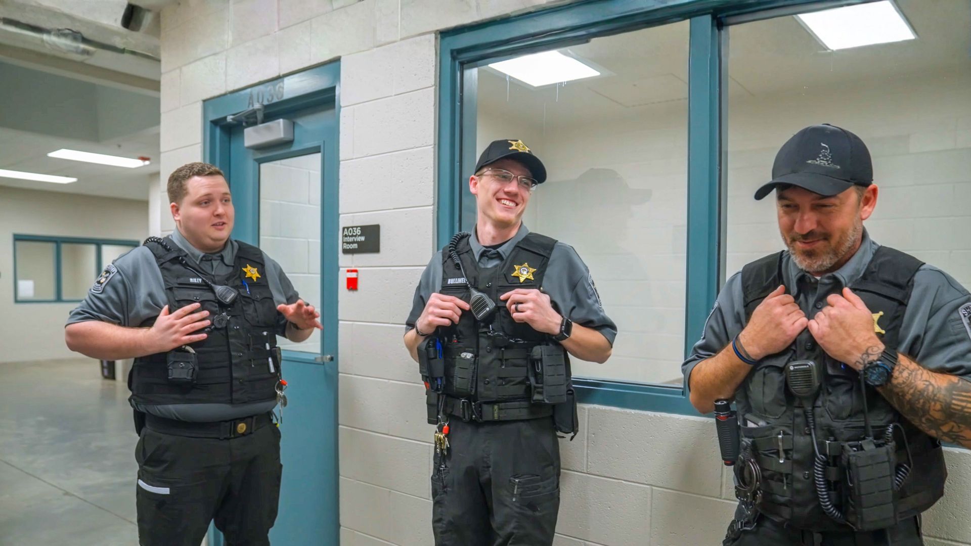 Three correctional officers talking in a jail corridor
