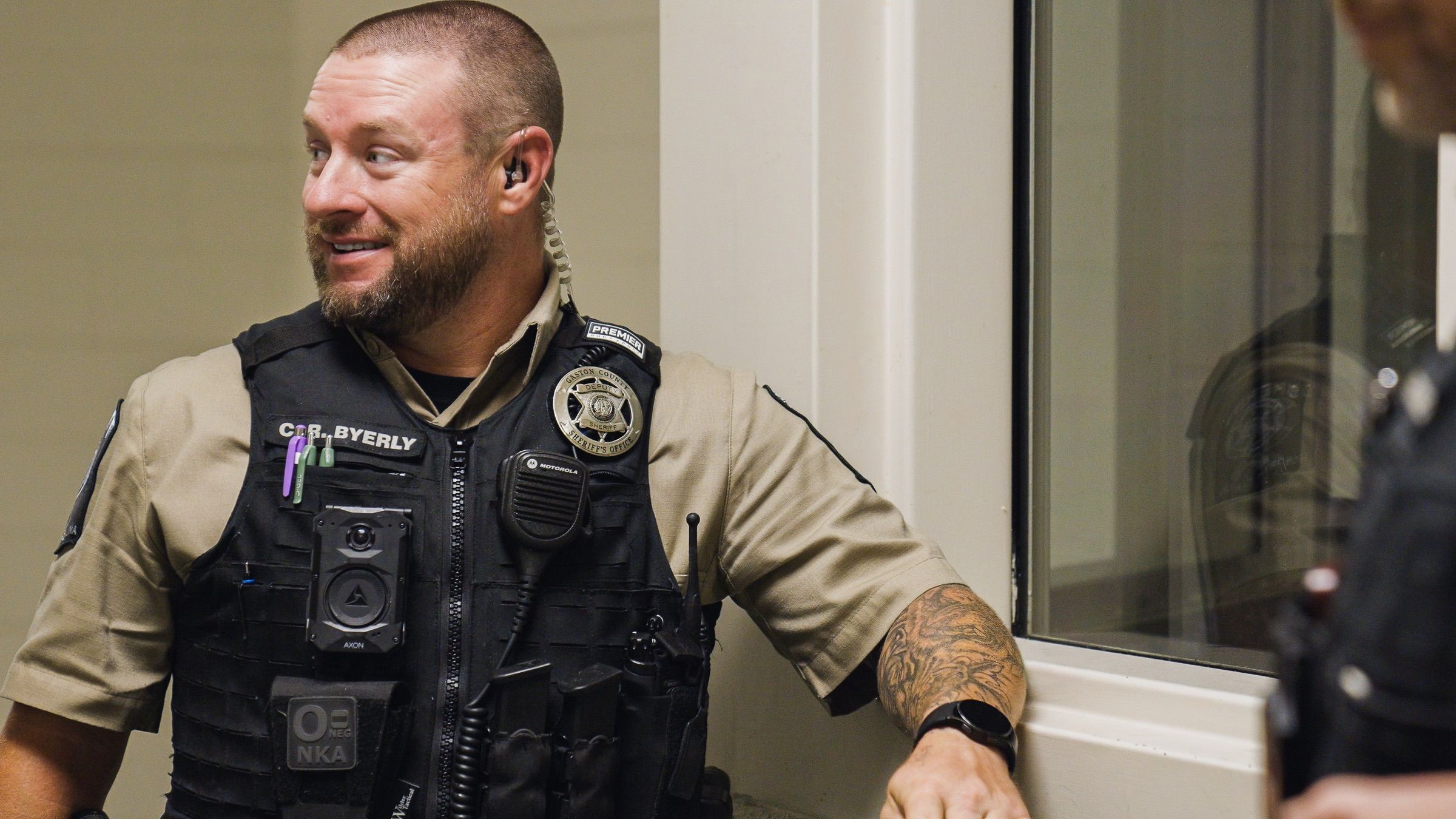 A corrections officer wearing a body camera talks with a colleague on a housing unit