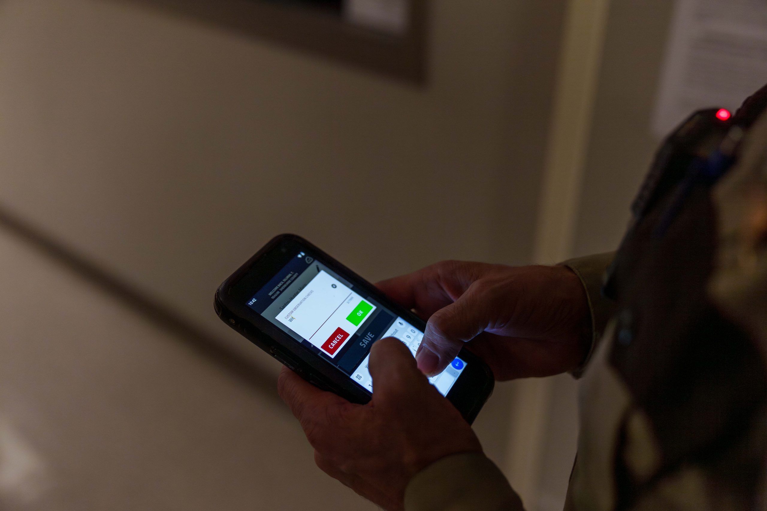 Corrections officer logging an observation check at the cell