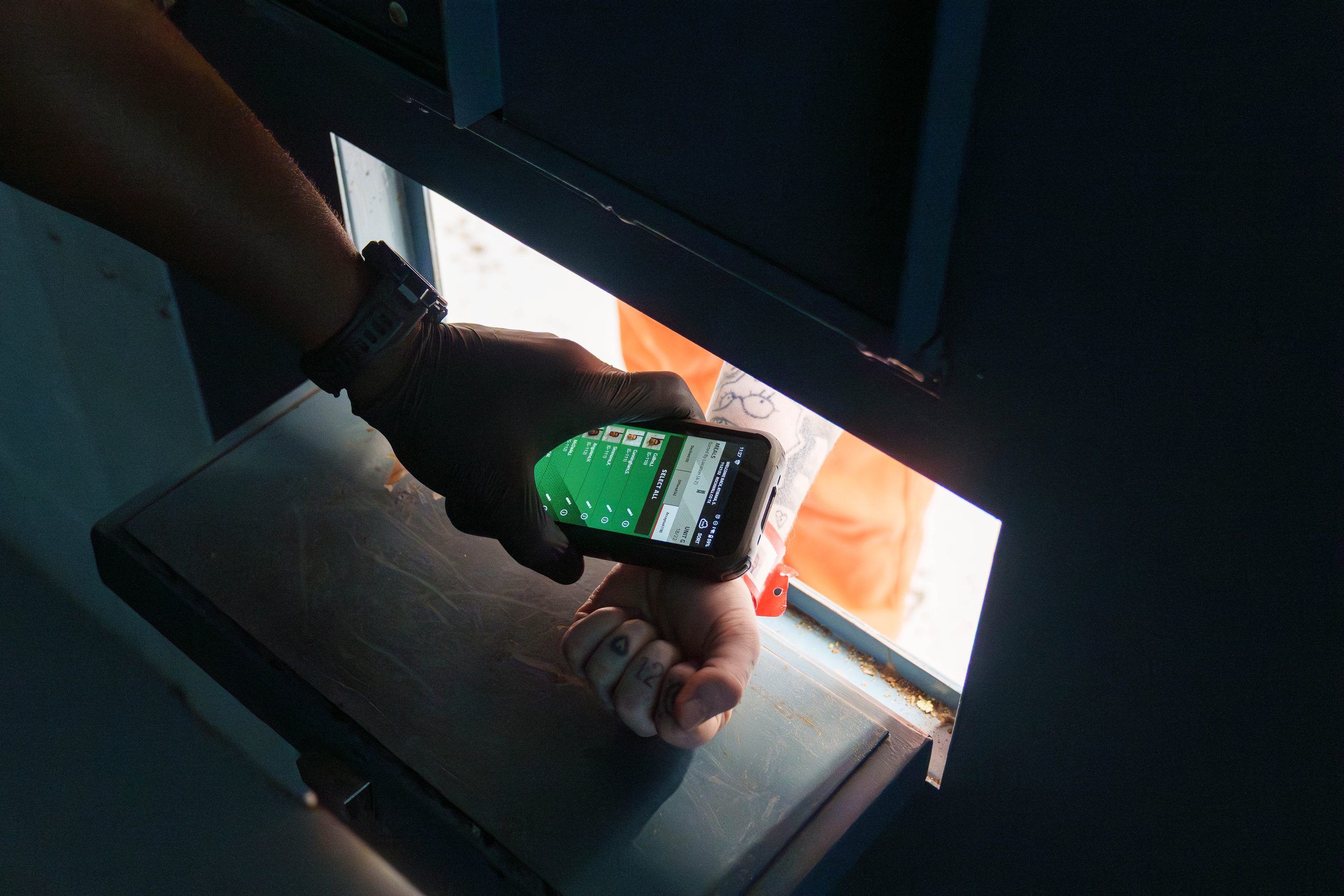 Officer using mobile inmate tracking software at a cell door