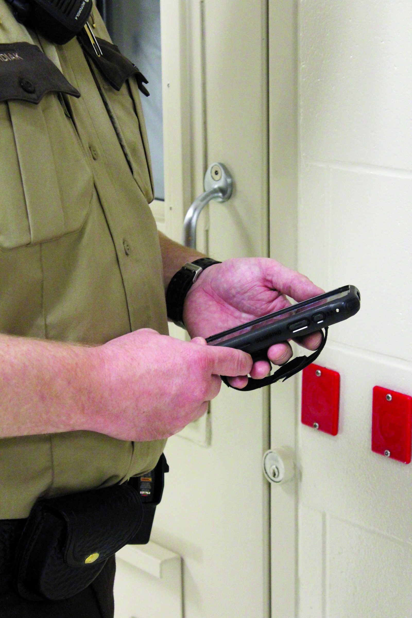 Officer scanning an RFID Hard Tag beside a cell door with SPARTAN 3