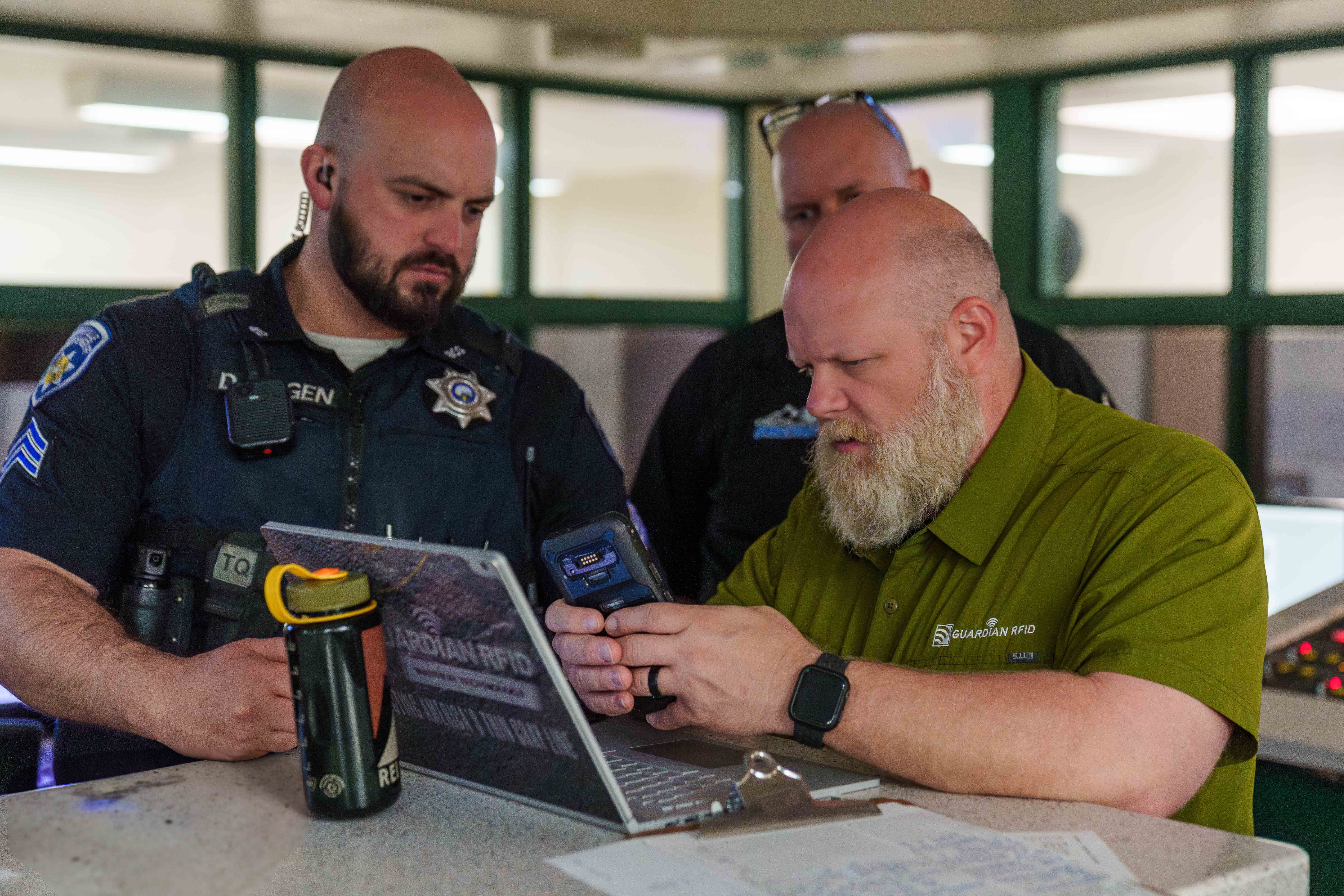 Corrections officer using a GUARDIAN RFID handheld scanner during a cell check