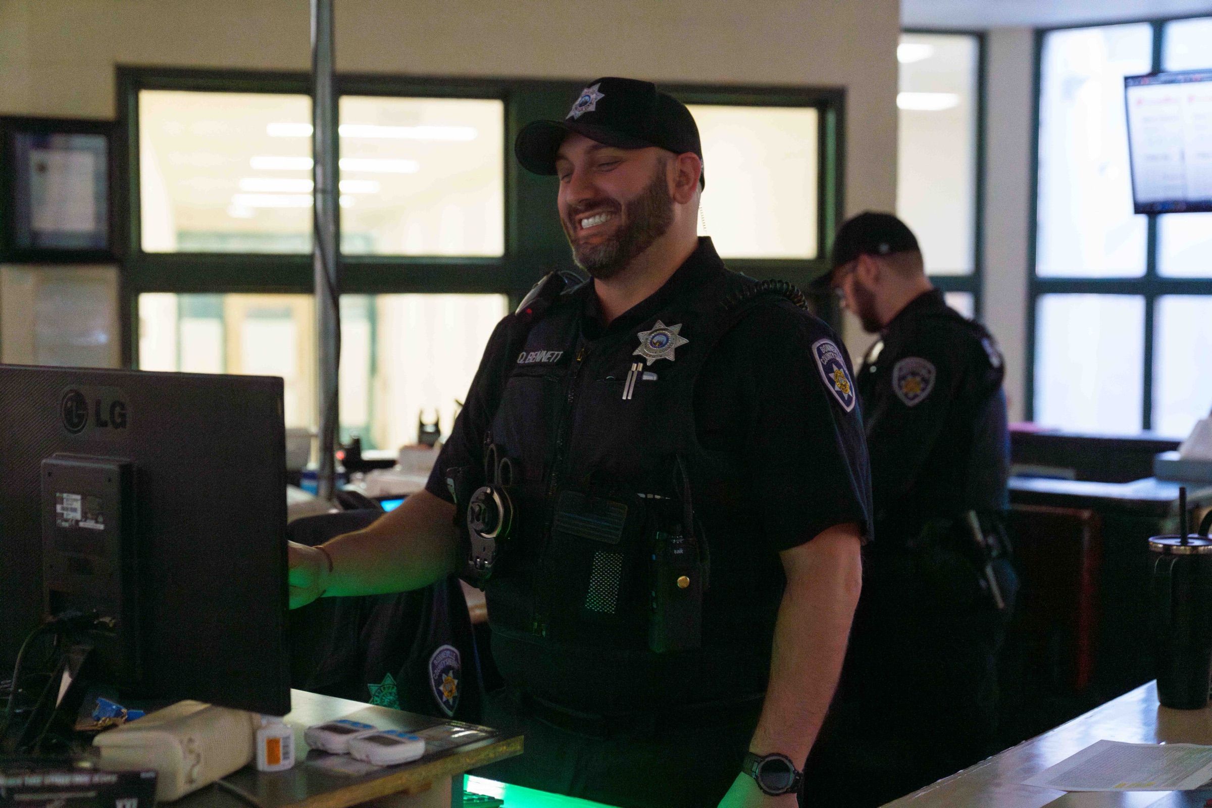 Smiling corrections officer working a duty station on an active jail floor