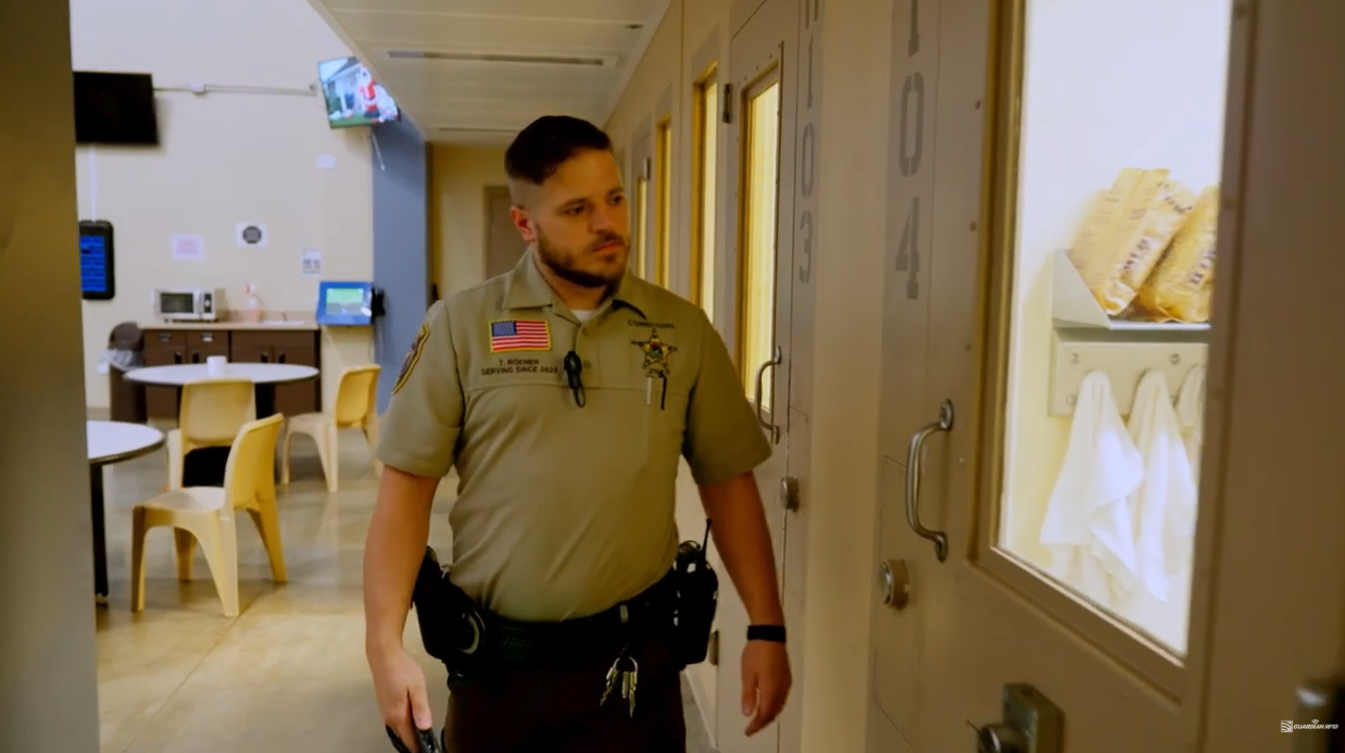 Officer standing in the doorway of a jail dayroom