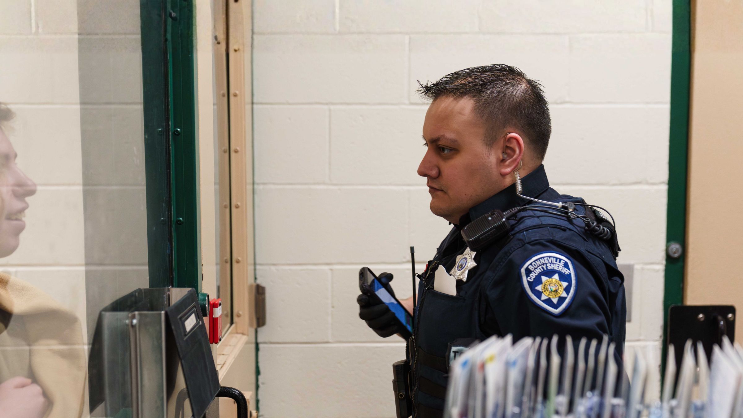 Officer scanning at a jail booking counter